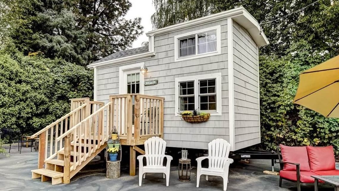 La tiny house Beach du Tiny Digs Hotel, à Portland, avec son porche et ses lucarnes