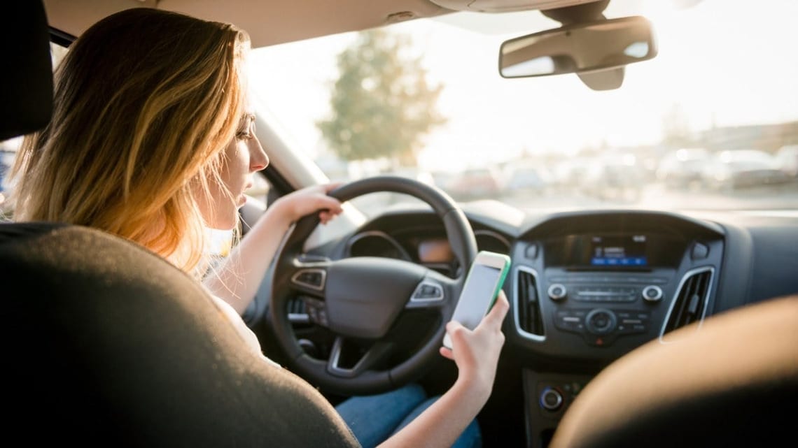 Une femme utilise son téléphone portable au volant