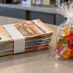 Une liasse de billets en euros posée à côté d'un petit sachet de bonbons oursons