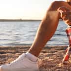 Un homme en train d'appliquer une solution anti-moustiques sur ses jambes 