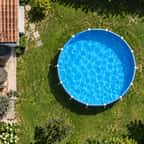 Vue aérienne d'une piscine hors-sol installée dans la pelouse d'un jardin pavillonnaire