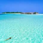 Une femme en train de nager dans un lagon des Maldives