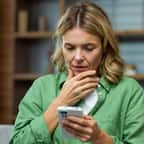 Une femme consultant son téléphone portable avec un air inquiet 