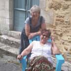 Jennifer et Kat posant assises devant leur maison en pierre du Périgord.