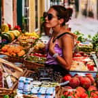 Une femme en train de choisir ses fruits et légumes en été chez le primeur