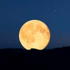 Une pleine lune se levant à l'horizon au crépuscule