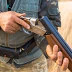 Un chasseur arme son fusil