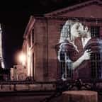 Ce street-artist projette des couples qui s'embrassent dans les rues de Paris, la nuit. Une ode à notre capitale de l'amour