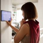 une femme utilise un thermostat chez elle
