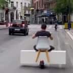 Vidéo : scène surréaliste à Bruxelles où un homme circule en trottinette avec une… armoire et une chaise