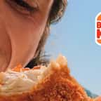 un homme croque dans un tenders Burger King