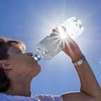 Femme buvant de l'eau en plein soleil