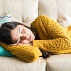 Jeune femme faisant al sieste dans le canapé