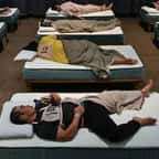 Participants en train de dormir sur des matelas durant la Matt Race au Japon