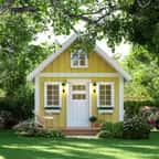 Tiny house jaune dans un jardin