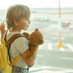 Un enfant avec son doudou à l'aéroport