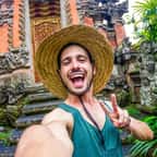 Un homme prend un selfie devant un temple à Bali