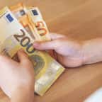 Un petit gar&ccedil;on qui compte ses billets d'euros