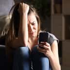 Une adolescente anxieuse qui consulte son téléphone portable 