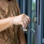 Une dame qui ouvre sa porte d'entrée 