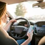 Une femme utilise son téléphone portable au volant