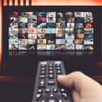 Une personne cherche un programme à regarder sur sa télévision