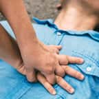Une personne fait un massage cardiaque &agrave; un homme