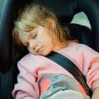 Une petite fille endormie dans une voiture
