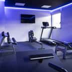 une salle de sport à la maison avec haltères et tapis de course