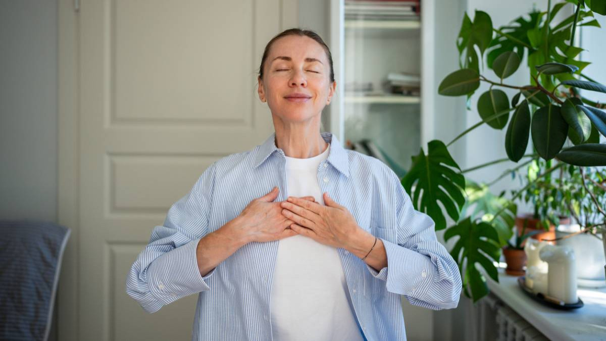 Femme souriant et détendue mains sur la poitrine