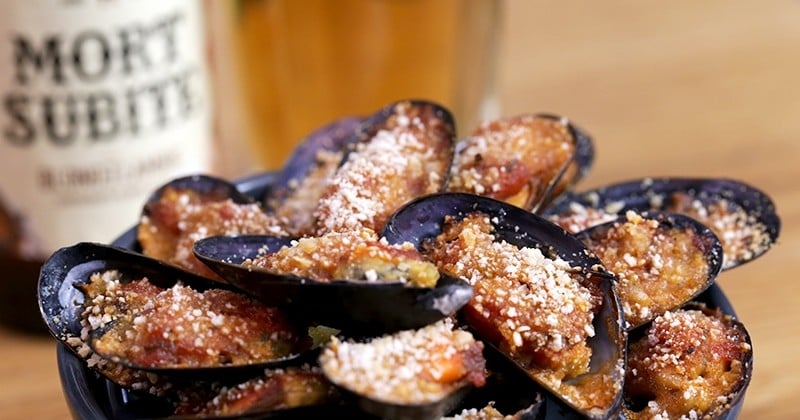 Pour un apéro original, servez de savoureuses moules farcies à la sauce tomate et gratinées à la chapelure et au parmesan servi avec une Mort Subite Blonde Lambic bien fraîche !