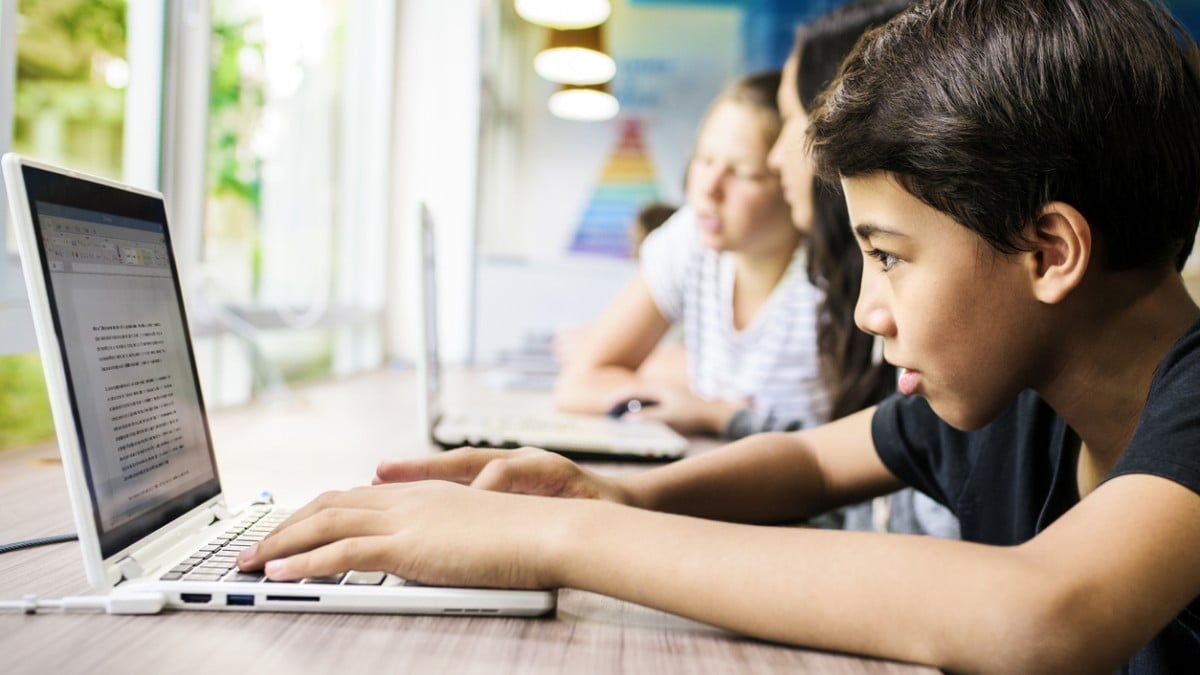 Un enfant écrit sur un ordinateur