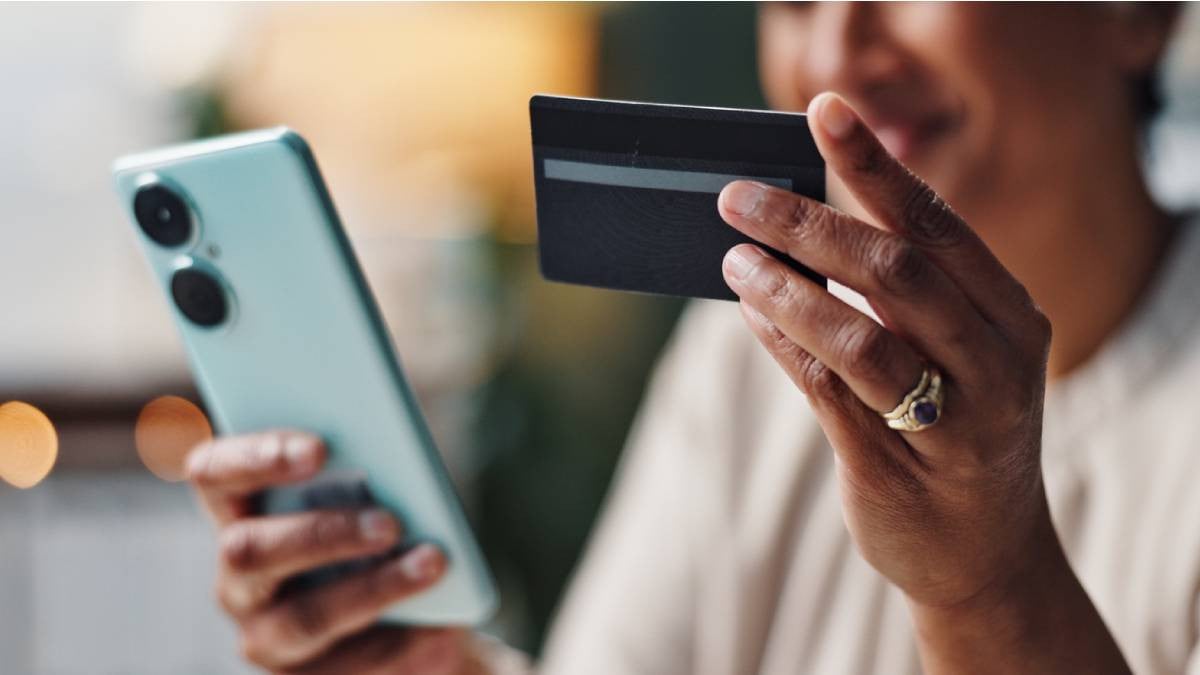 Femme effectuant un virement avec sa carte de crédit et son smartphone