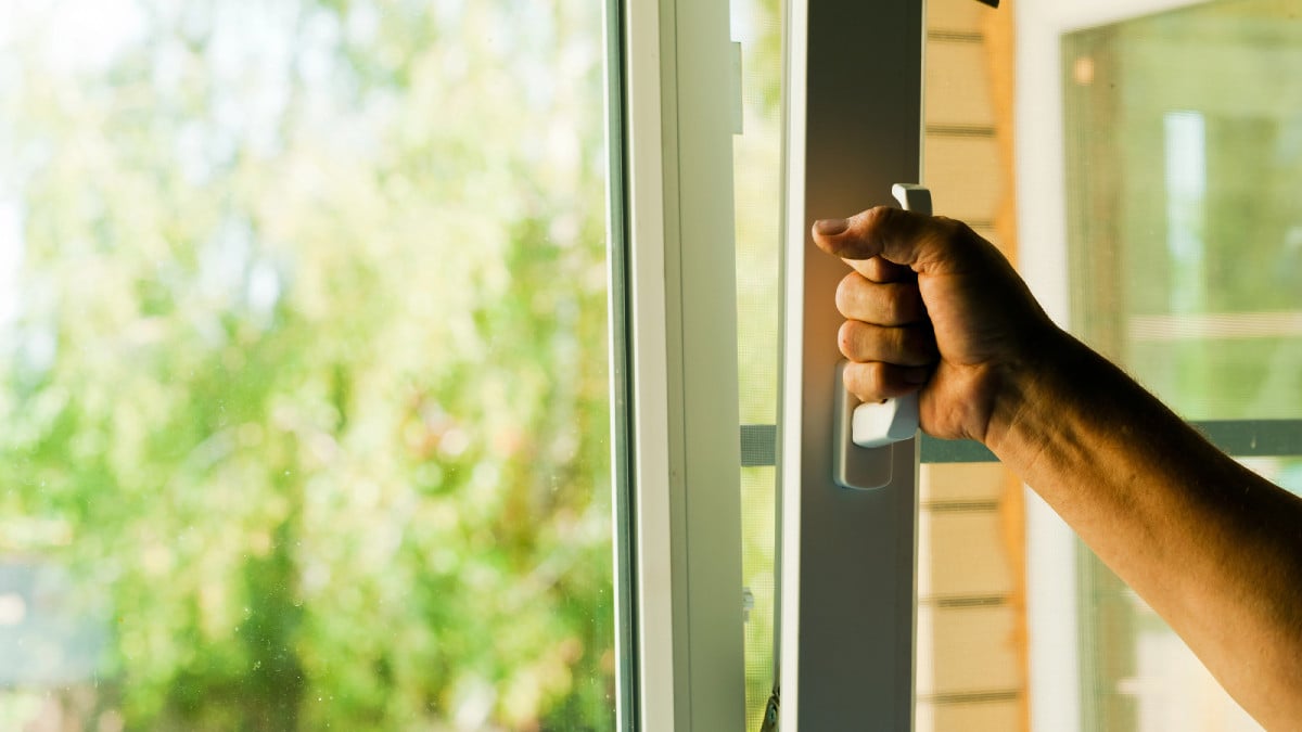 un homme ouvre sa fenêtre