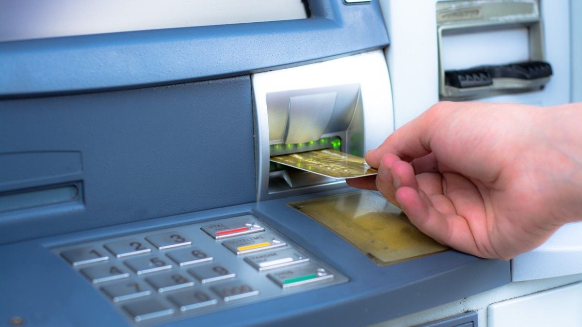 Une personne insère une carte bancaire dans une machine