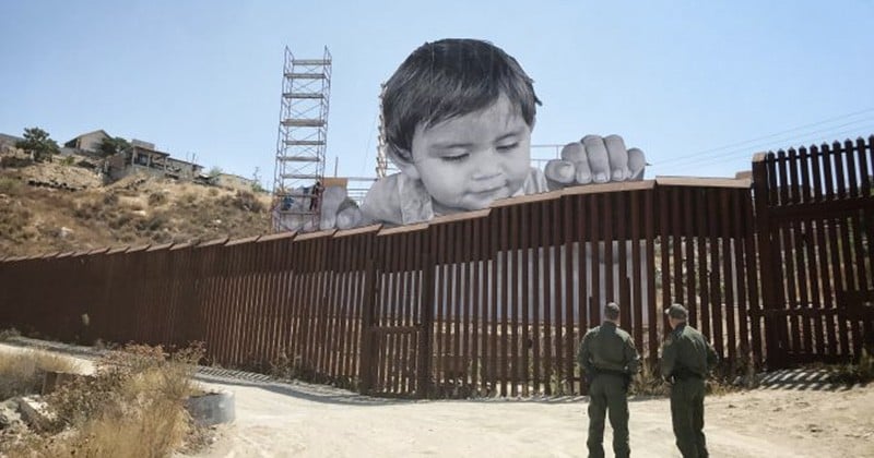 La photo d'un enfant mexicain curieux surplombe la barrière séparant le Mexique des États-Unis