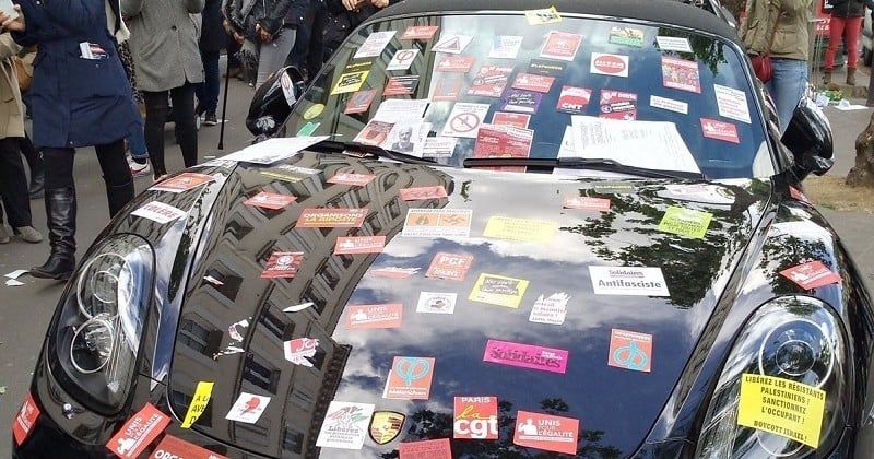 Les manifestants du 1er mai ont pris un malin plaisir à décorer cette Porsche mal garée avec des autocollants... La réaction du proprio est sans équivoque !