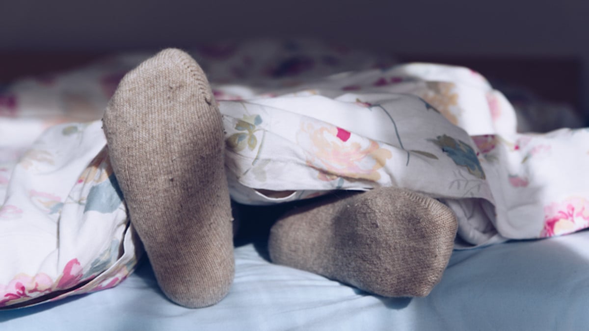 Un homme porte des chaussettes pendant son sommeil
