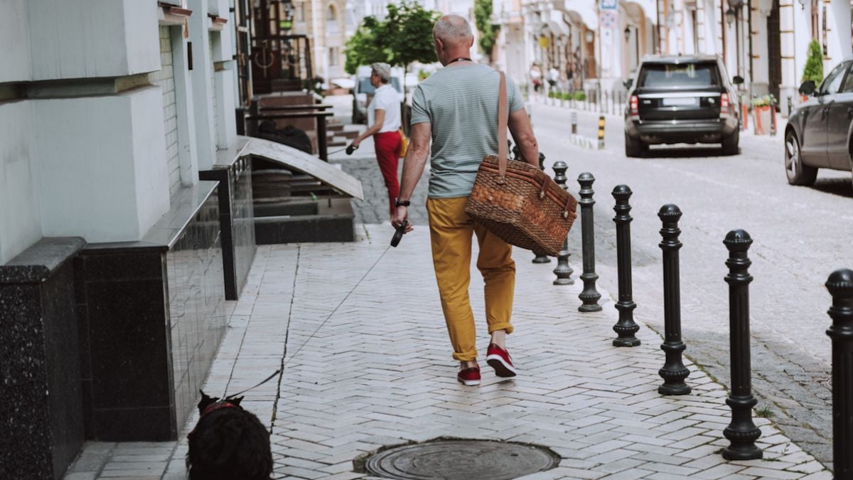 Un homme en train de promener son chien dans la rue