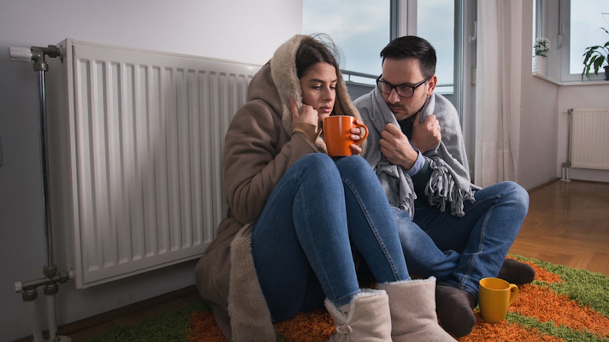 Un couple se réchauffe près du radiateur