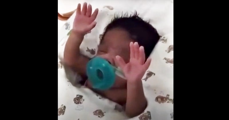 Alors que sa maman lui chante une chanson pour l'encourager, ce bébé prématuré placé en soins intensifs lève les bras au ciel 