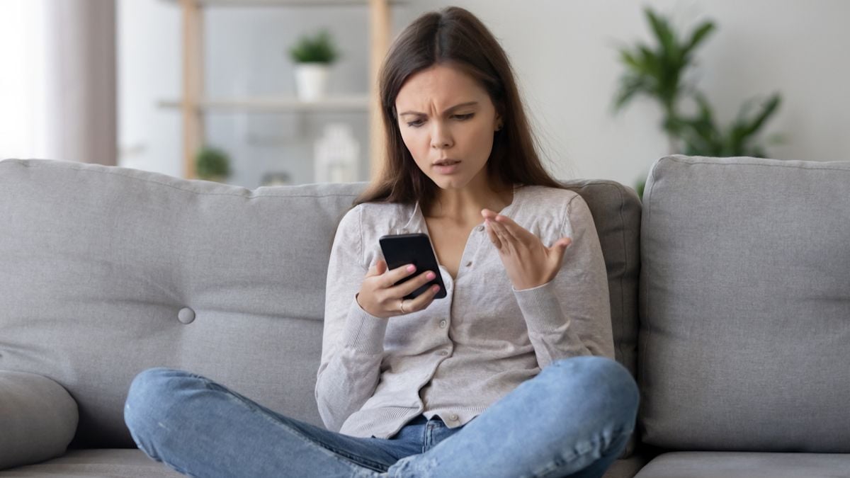 Une femme en colère qui regarde son téléphone portable 