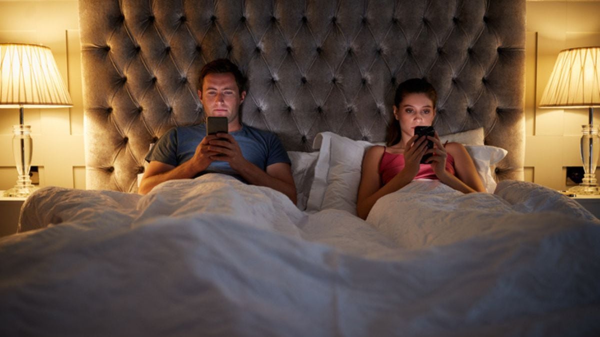 Couple dans un lit sur son téléphone