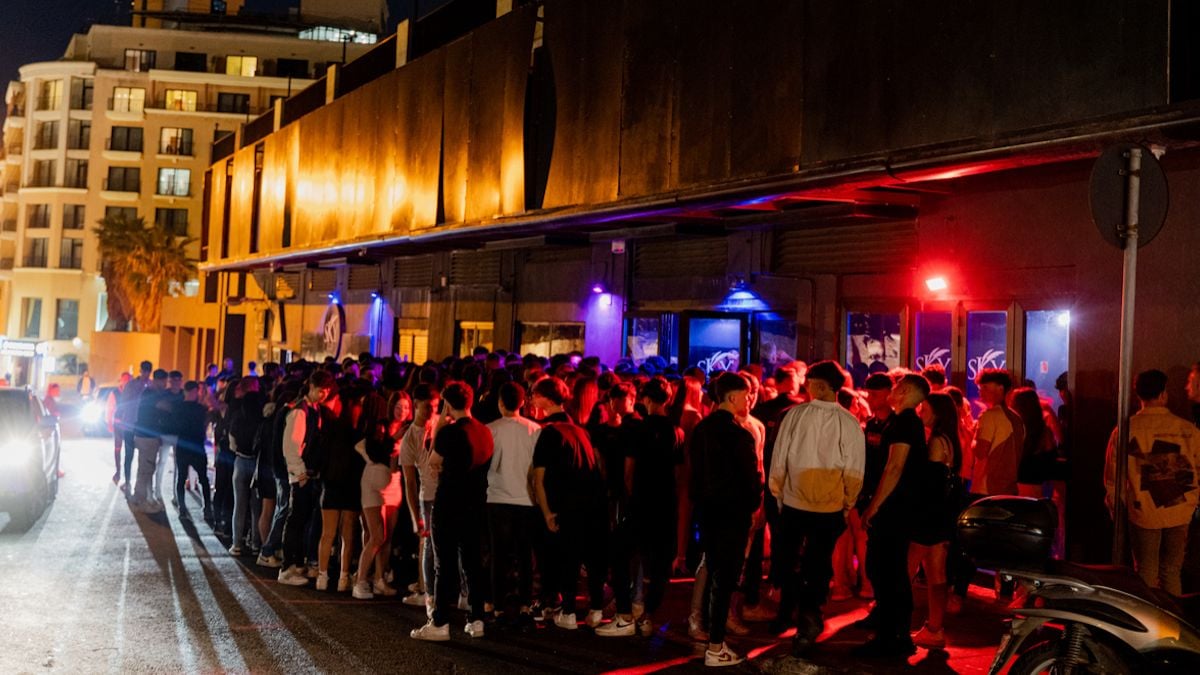 Des gens en train de faire la queue devant une boîte de nuit 