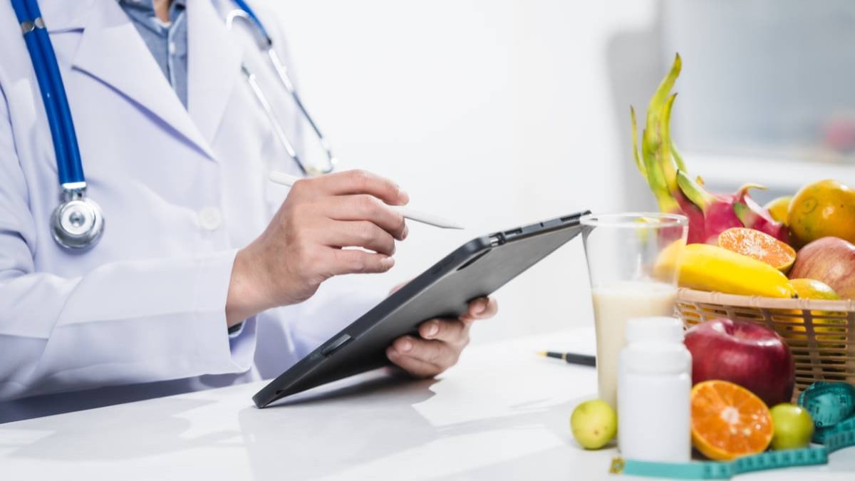 Nutritionniste à côté d'un plateau de fruits