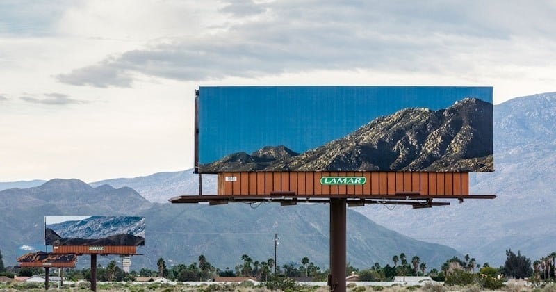 Sur ces panneaux publicitaires qui cachaient le paysage, des artistes ont posé justement des photos du paysage par-dessus !