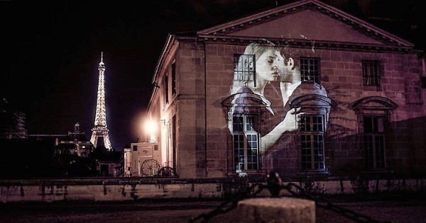Ce street-artist projette des couples qui s'embrassent dans les rues de Paris, la nuit. Une ode à notre capitale de l'amour