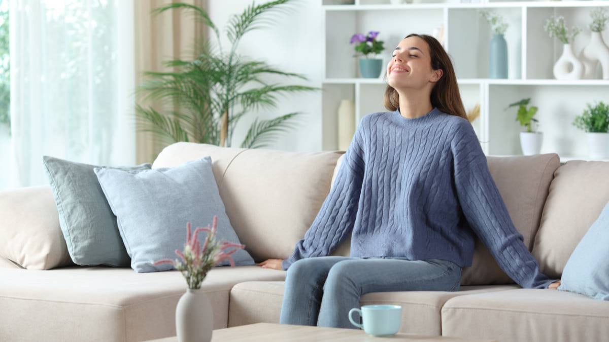 Femme heureuse assise sur son canapé