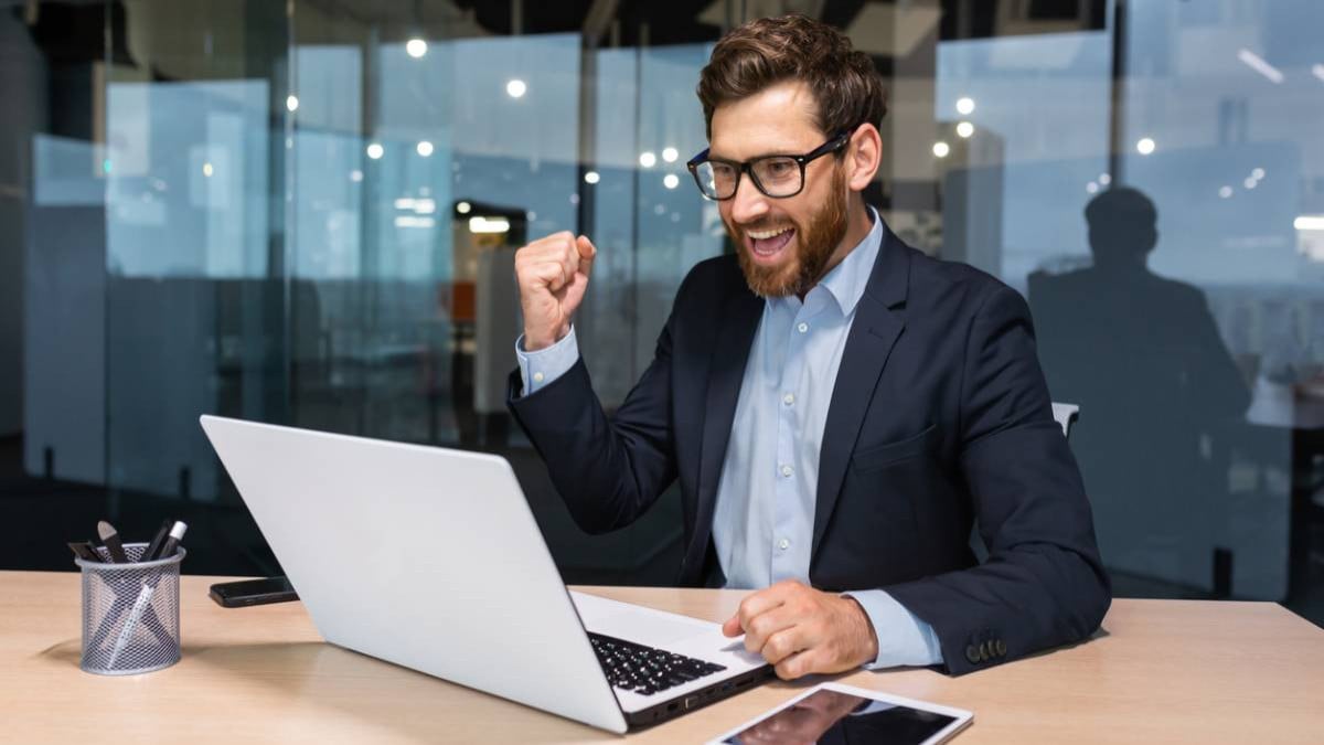 Homme d'affaires content devant son ordinateur