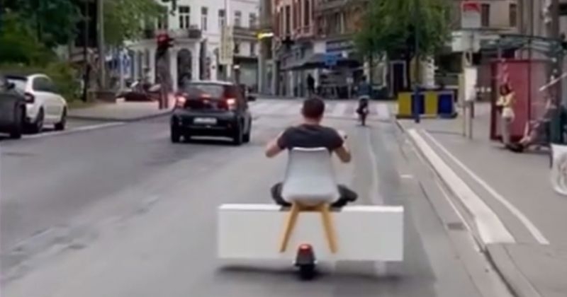Vidéo : scène surréaliste à Bruxelles où un homme circule en trottinette avec une... armoire et une chaise